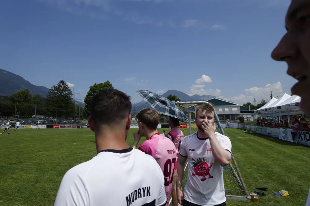 Ein Himbis lacht in seinem weißen Trikot am Spielfeldrand
