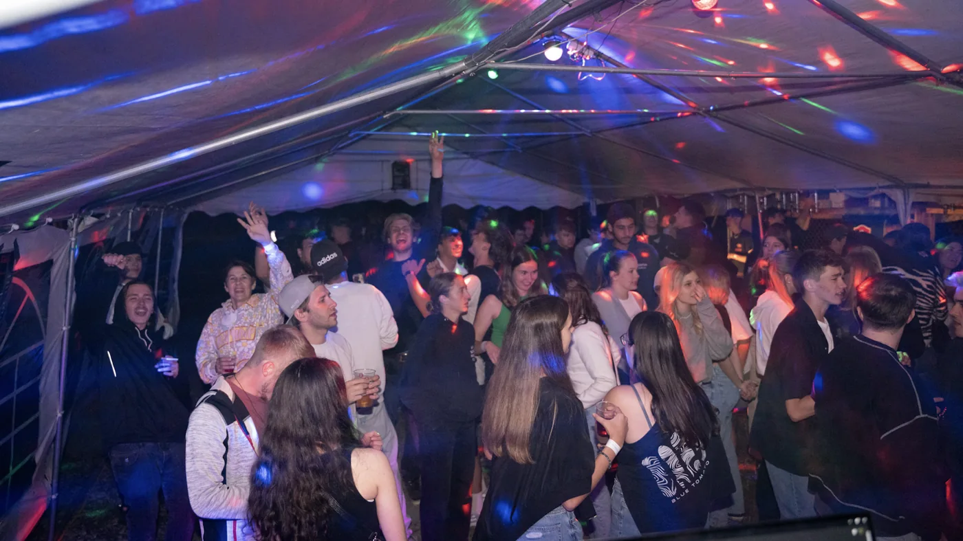 Feiernde Gäste im bunten Licht des ersten Himbis-Fests