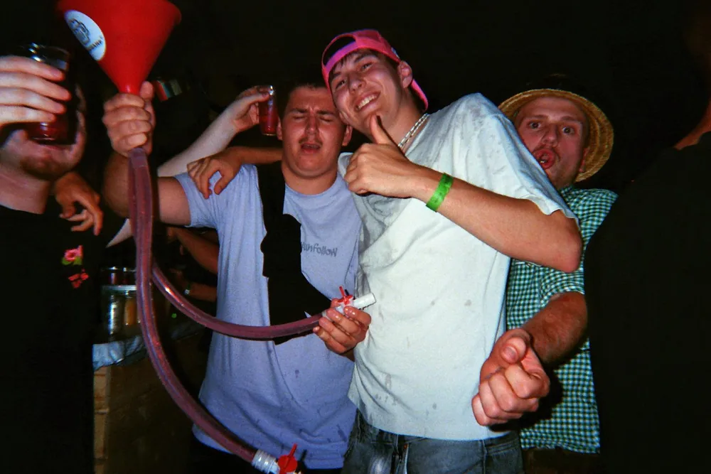 Freunde mit Kappe und Hut feiern gemeinsam und lachen in die Kamera