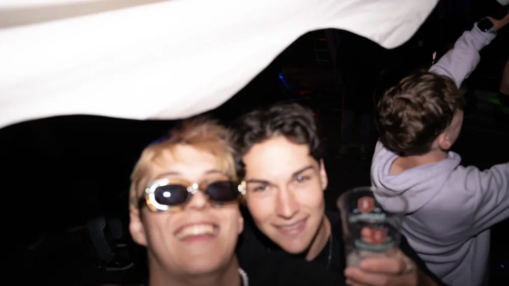 Freunde mit Sonnenbrille lachen gemeinsam in die Kamera